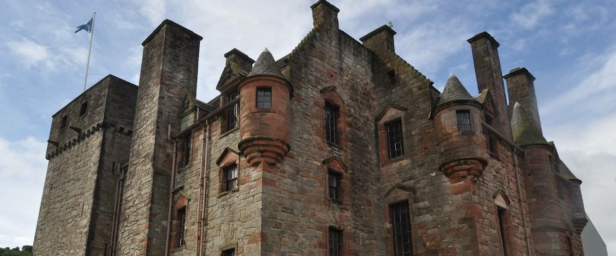 A large stone castle with multiple towers and a flag on top.