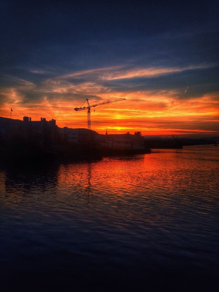 Looking over at Port Glasgow with the crane from a shipyard silhouetted against a nice sunset on the Clyde coast. 