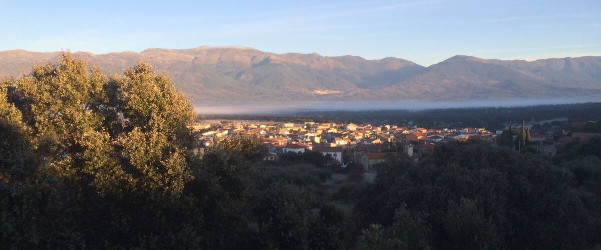 A town nestled between mountains and trees.