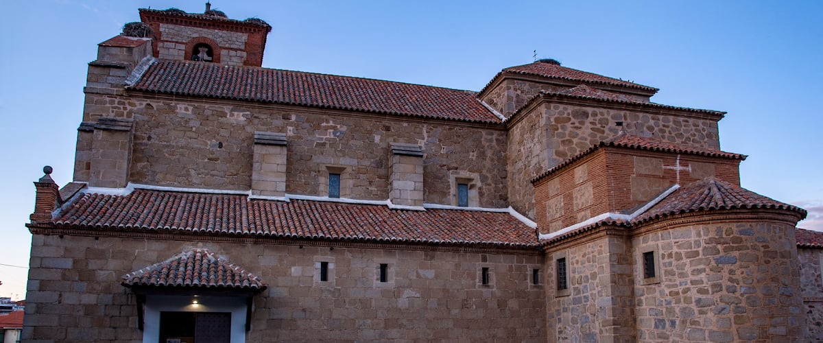 A historic stone building with a tiled roof and a bell tower.
