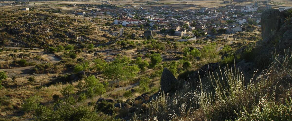 A town nestled in a valley with mountains in the background.