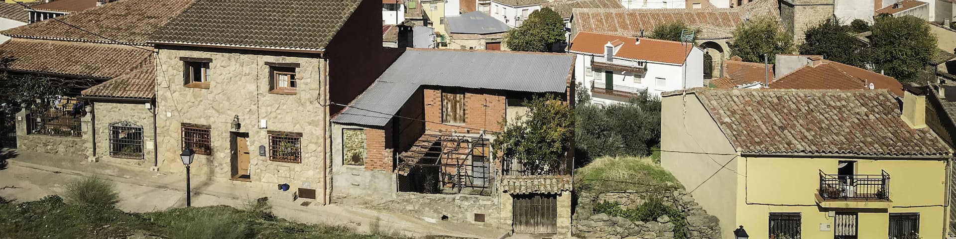 Aerial shot of small buildings near mountains in Hinojosa de San Vicente, Toledo, Spain
