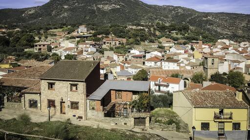 Aerial shot of small buildings near mountains in Hinojosa de San Vicente, Toledo, Spain