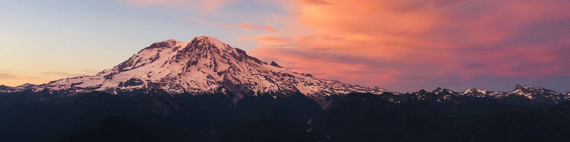 A snow-capped mountain under a colorful sky.