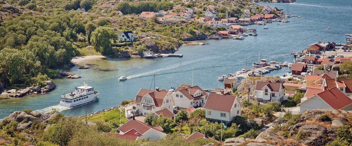 A coastal village with houses, a boat, and rocky terrain.