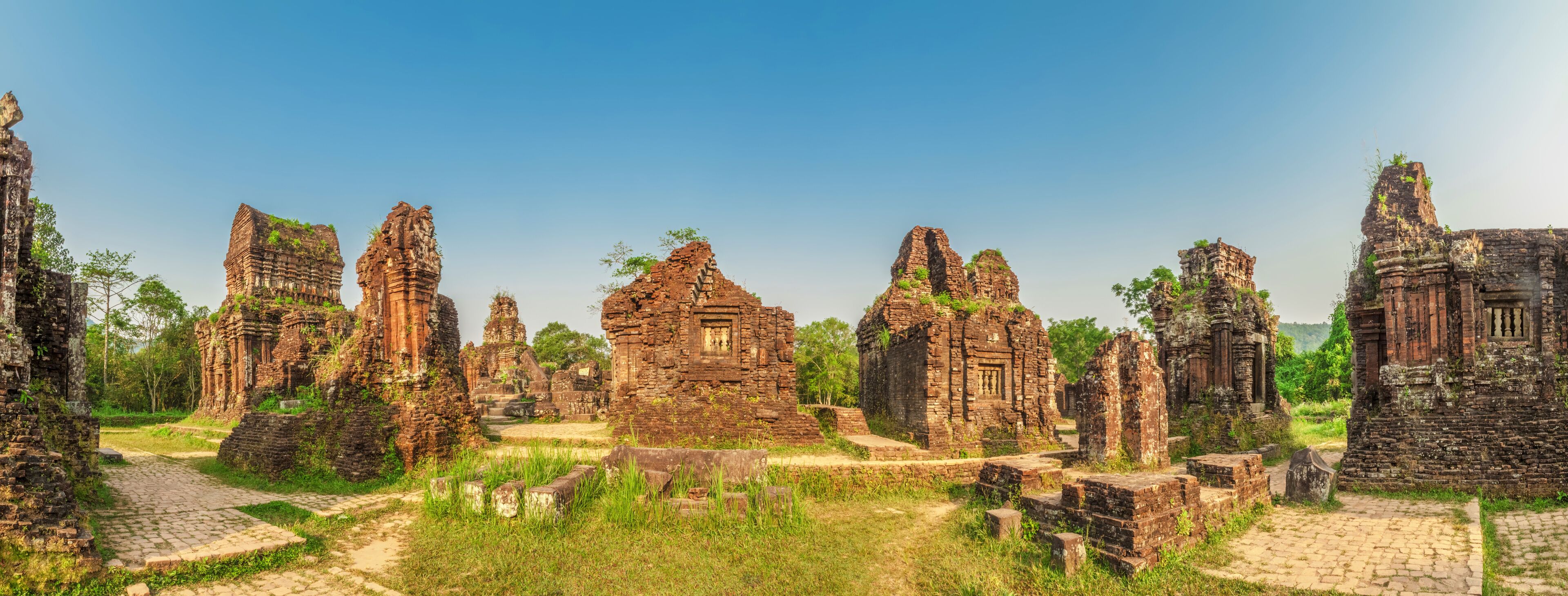 Ancient stone ruins with intricate carvings and overgrown vegetation.