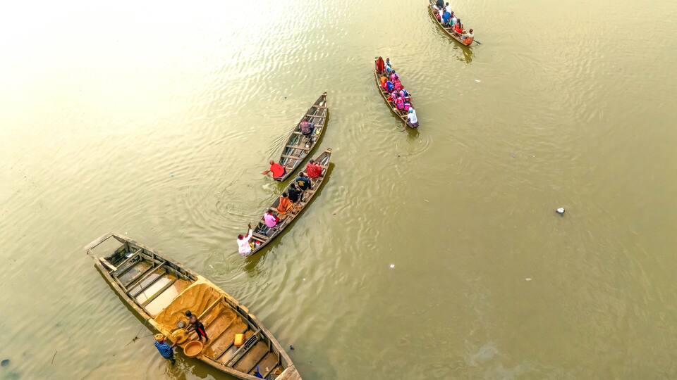 Aerial view of boats floating on the river, their colorful passengers a vibrant contrast to the muddy waters, Kpansia, Yenagoa, Bayelsa State, Nigeria.