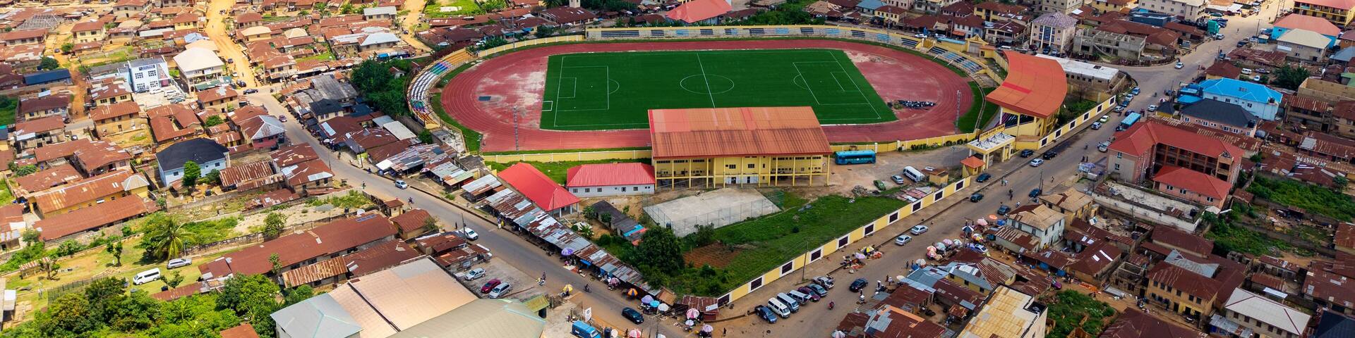 Aerial view of the stadium nestled in the heart of the city, surrounded by a tapestry of terracotta rooftops and lush greenery, Ado Ekiti, Ekiti, Nigeria.
