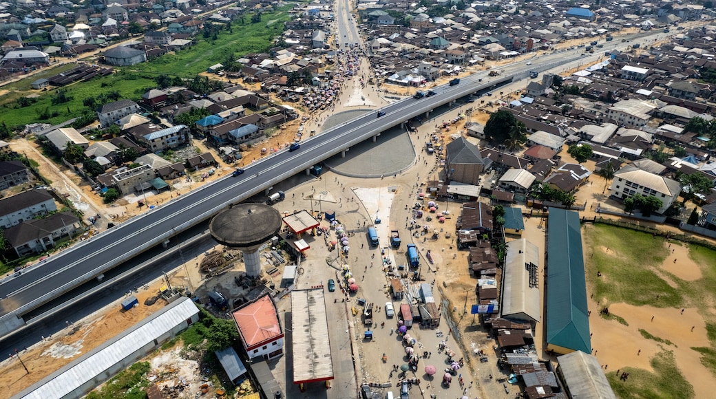 Aerial view of a bustling urban intersection with a modern overpass cutting through a dense residential area, enhancing connectivity, Asaba, Delta State, Nigeria.