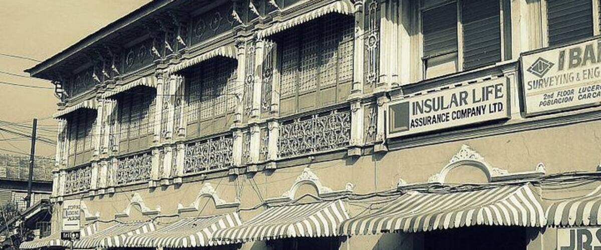 A building with ornate architectural details and signage for 'INSULAR LIFE Assurance Company Ltd.' and 'B.A. Surveying & Engineering'.