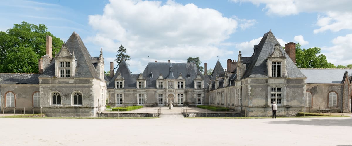 A historic building with multiple towers and a central courtyard.