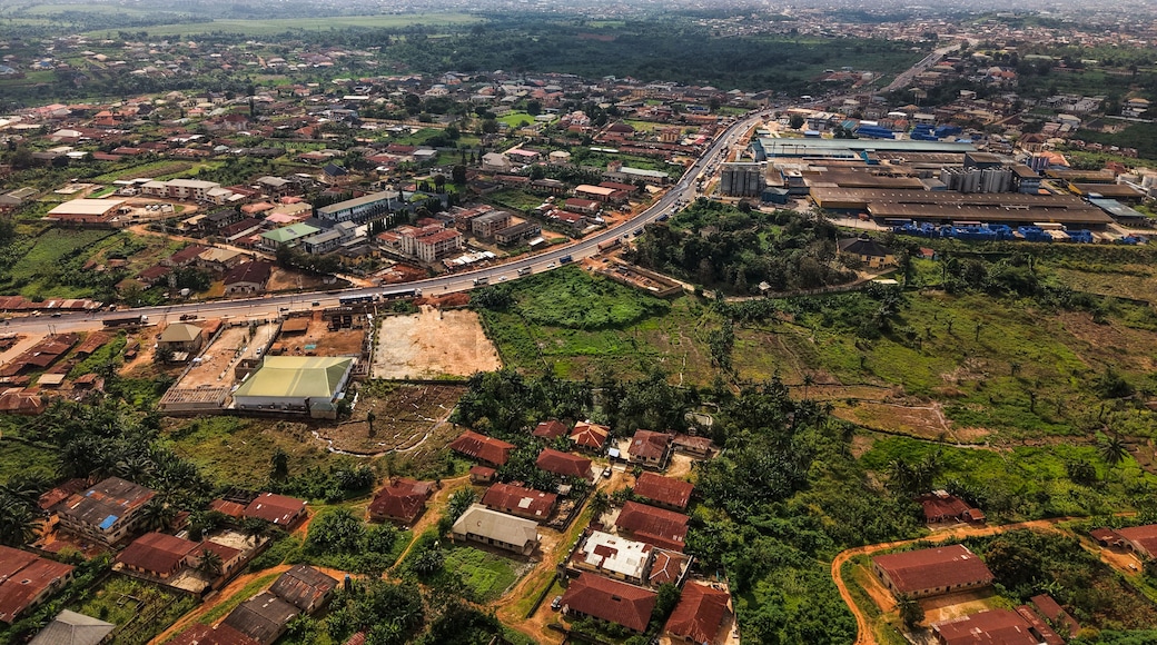 Aerial view of rooftops blending into the verdant landscape, a road cutting through the expanse of the city, Ilesa, Osun, Nigeria.