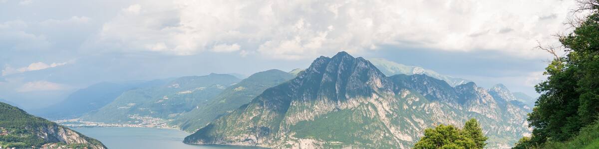 View from "Big Bench" to Lake Iseo and Mount Corna Trentapassi at sunny day with clouds. Fonteno, Bergamo, Lombardy, Italy.