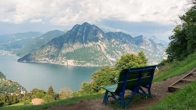 A bench overlooking a lake with mountains in the background.
