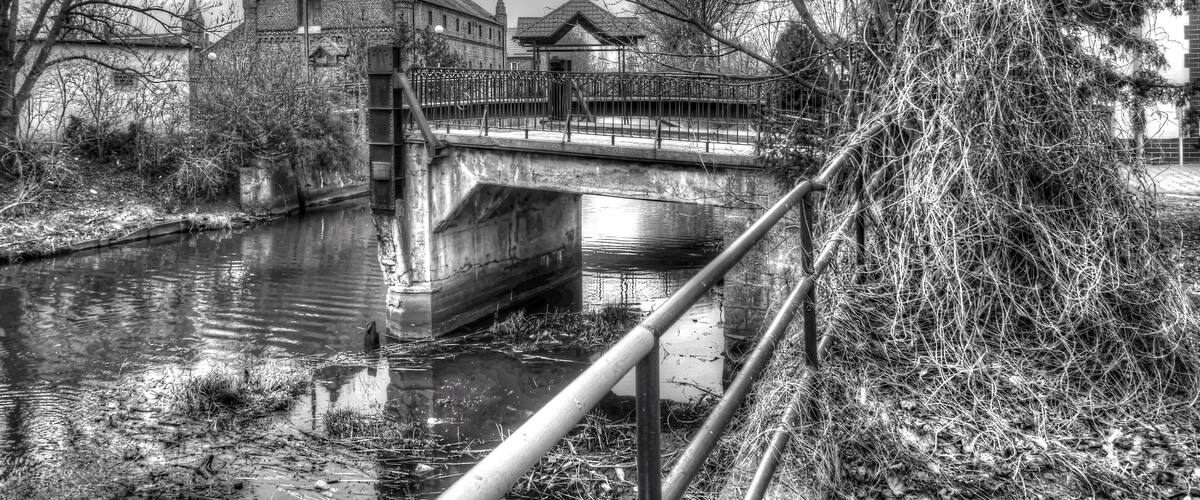 A bridge over a canal with buildings on either side.