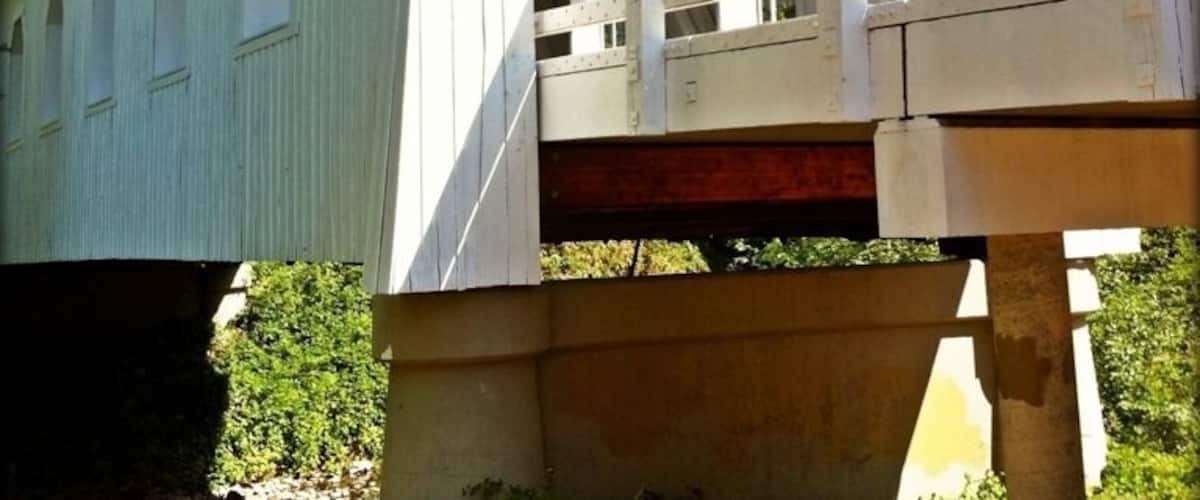 A white covered bridge with the name 'GRAVE CREEK' on it.