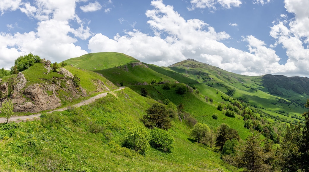 Panorama of Trialeti (Caucasus) mountain range with Tskhratskaro Pass, Georgia, gravel dangerous M-20 road and green grasslands in summer, high resolution.