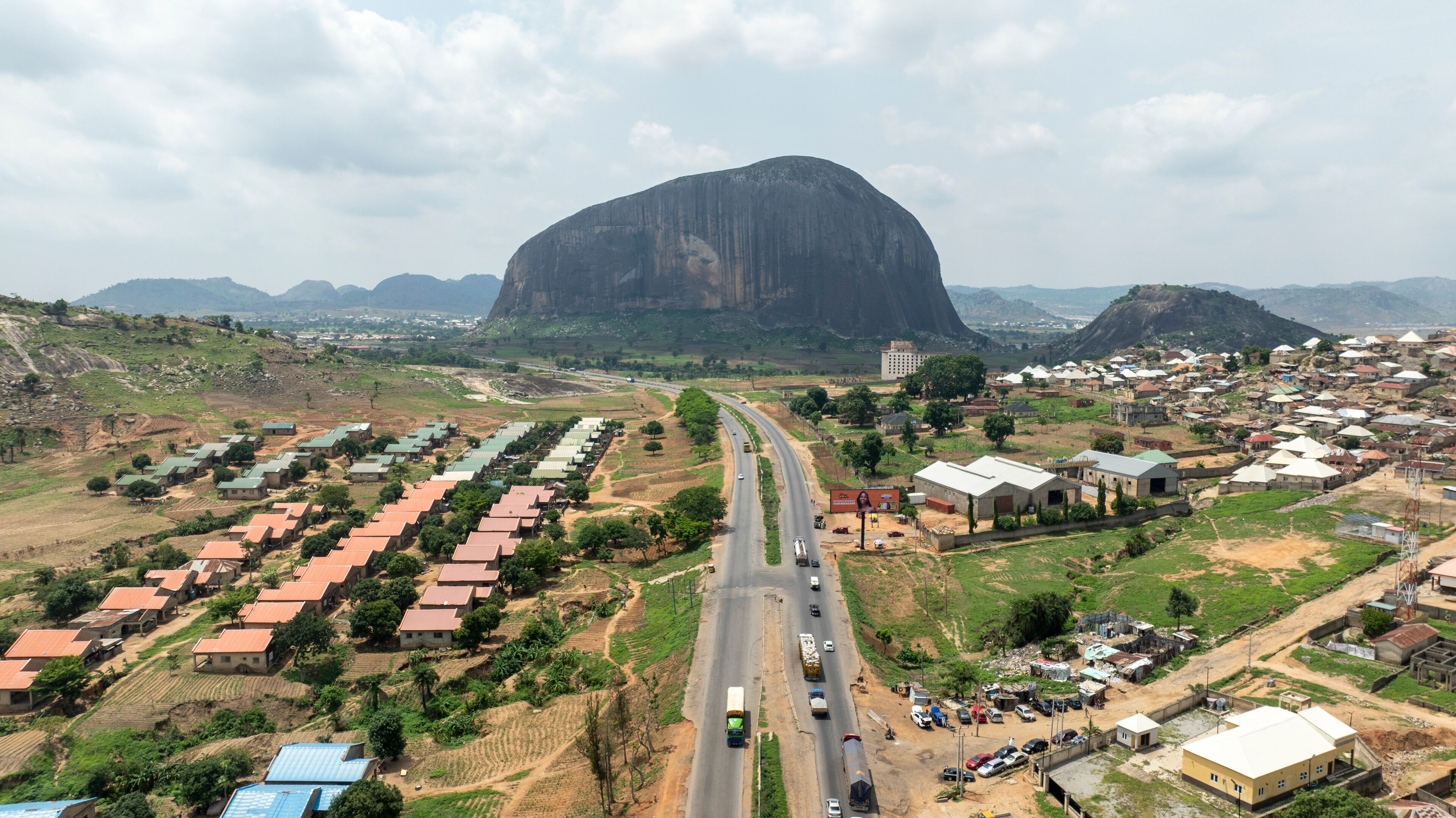 A town with a prominent mountain in the background, a main road, and residential areas.