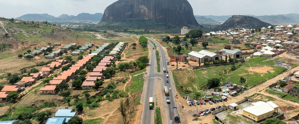 A town with a prominent mountain in the background, a main road, and residential areas.