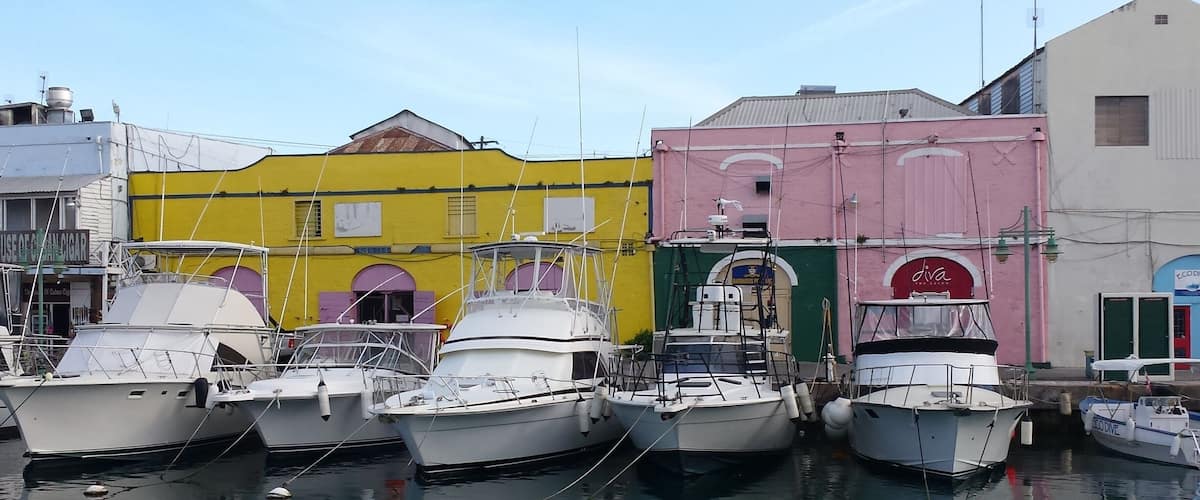 A marina with several boats docked in front of colorful buildings.