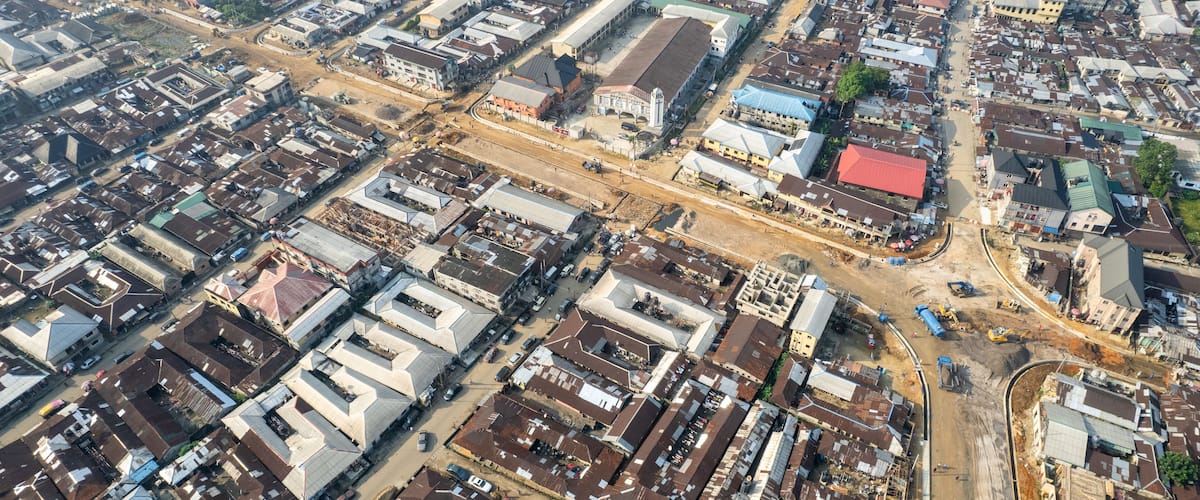 An aerial view of a densely packed urban area with numerous buildings, roads, and construction sites.