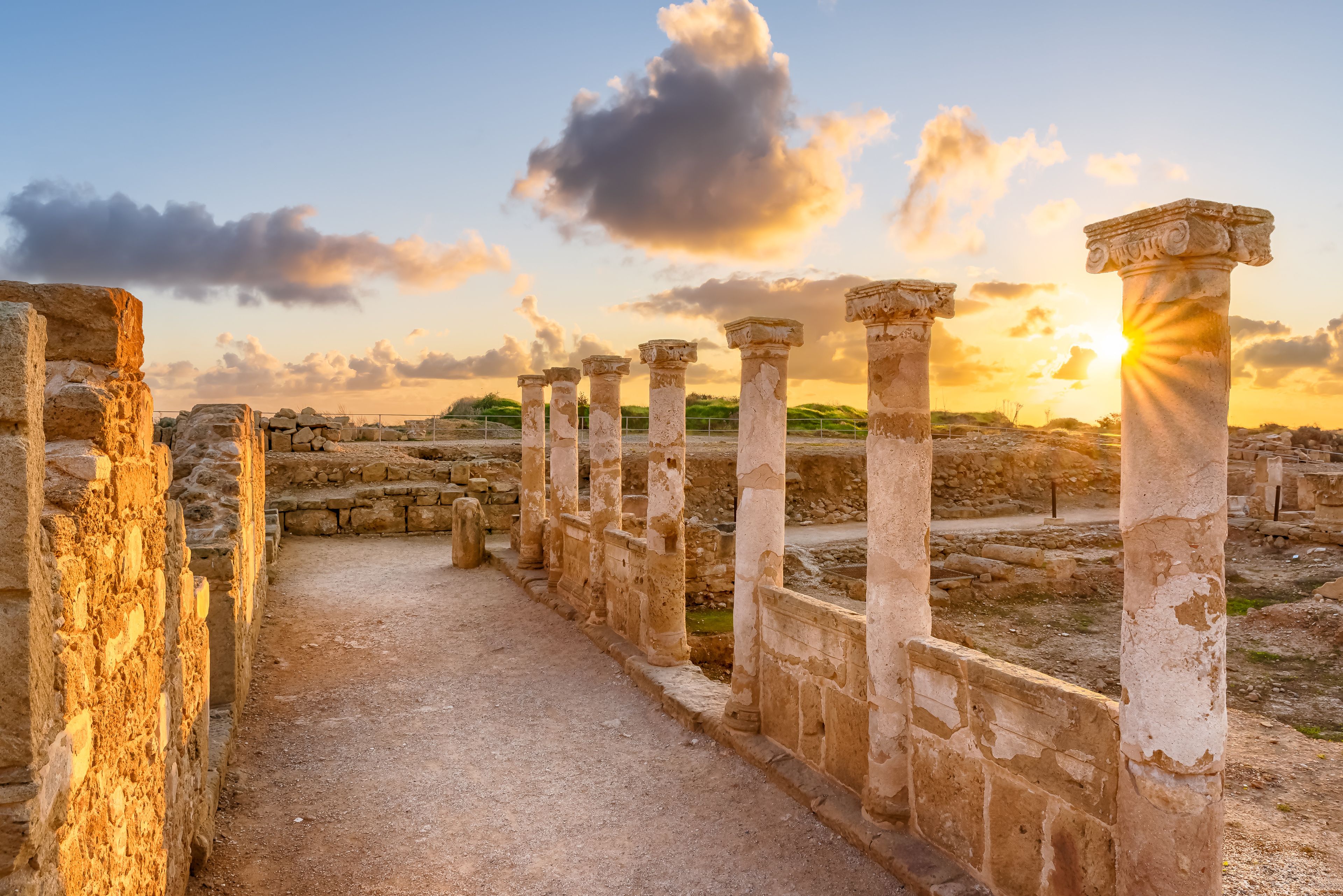 Ancient stone columns and ruins at sunset.