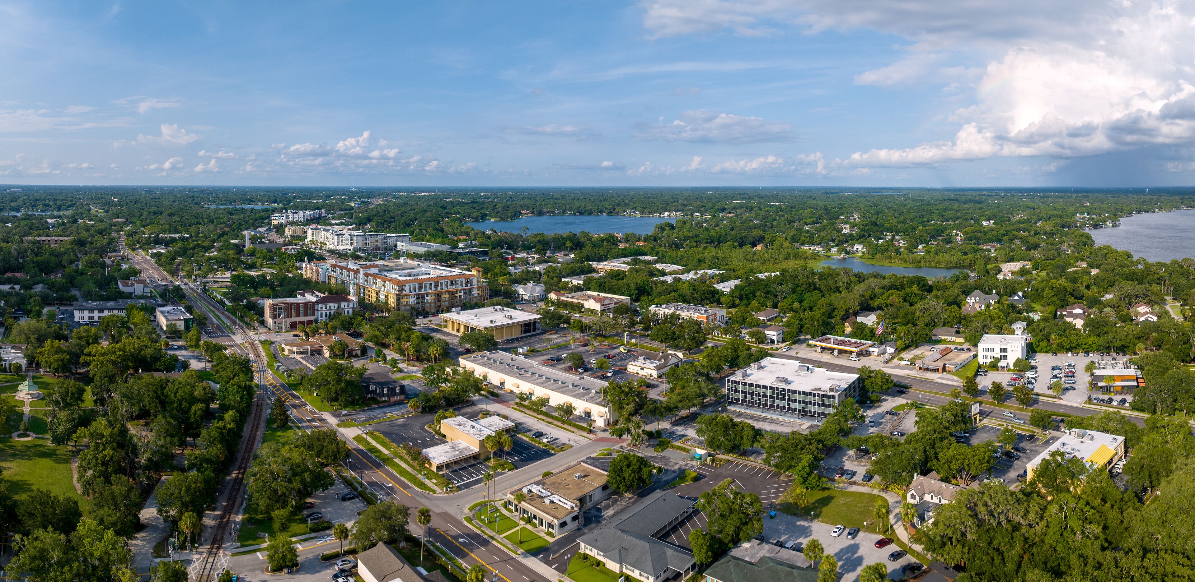 An aerial view of a city with a river, buildings, and green spaces.