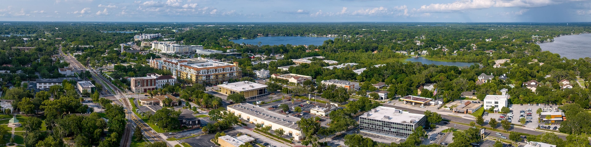 An aerial view of a city with a river, buildings, and green spaces.
