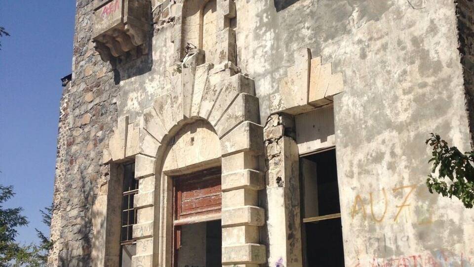 An old, abandoned building with graffiti and broken windows.