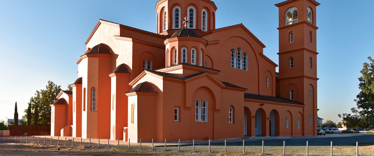 Una iglesia anaranjada grande con múltiples torres y ventanas de arco.