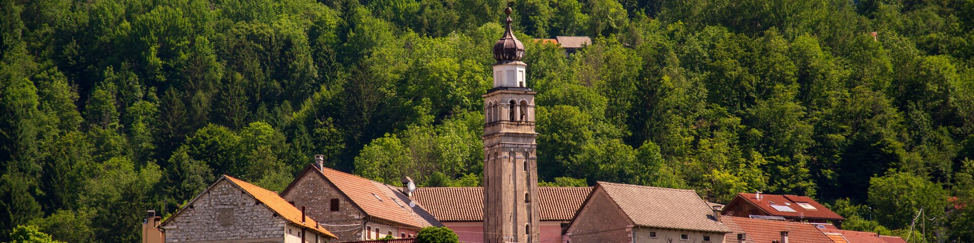 Un pueblo con casas de piedra y una torre destacada.