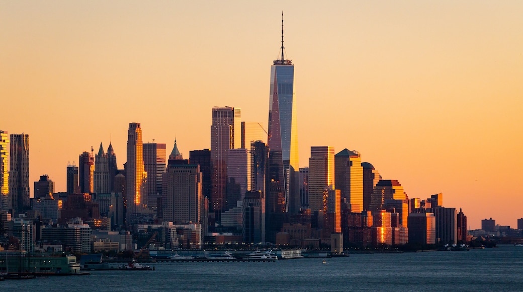 Lower Manhattan showing a bay or harbor, a sunset and a city