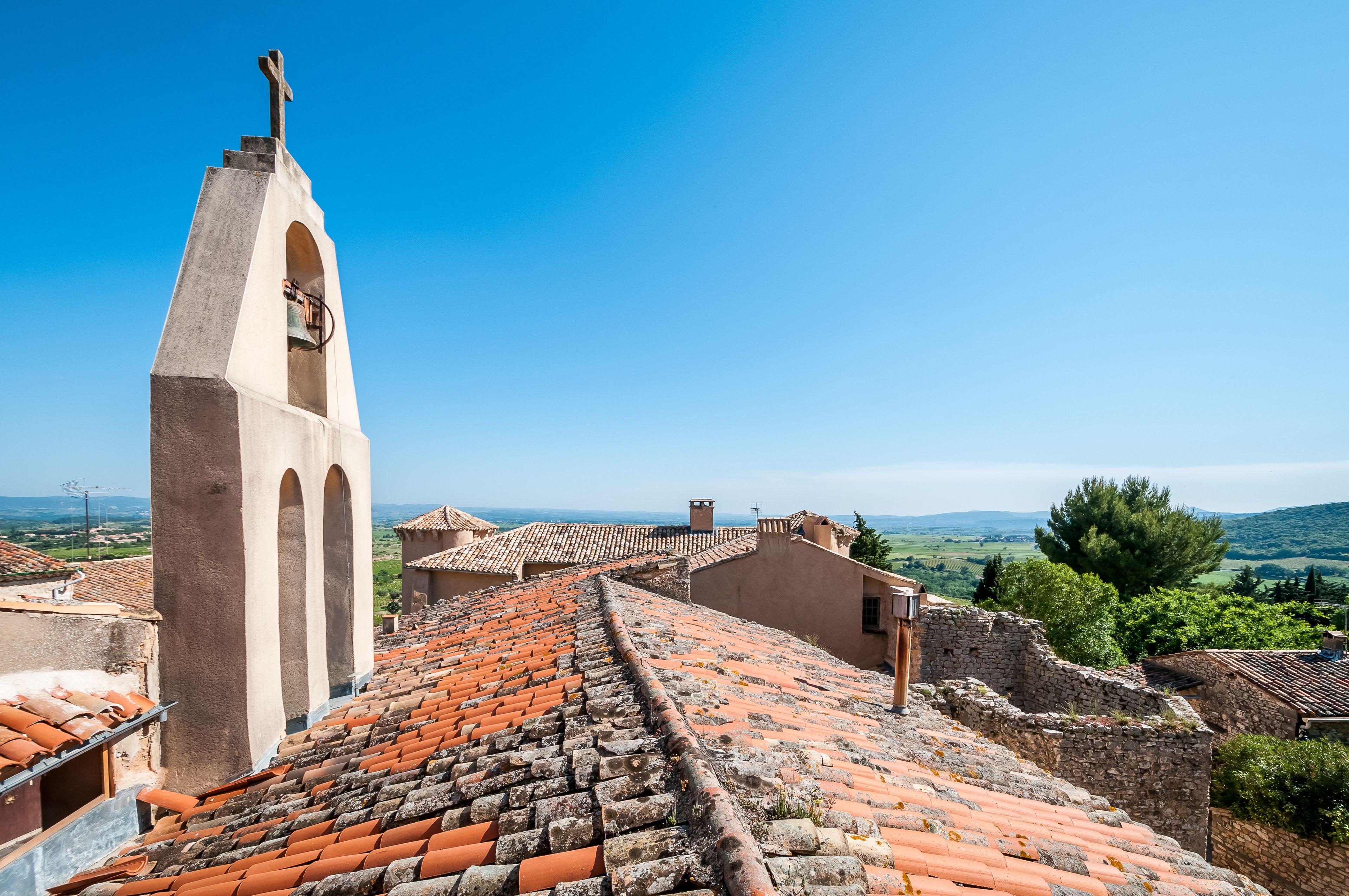 A church with a bell tower and a view of the countryside.
