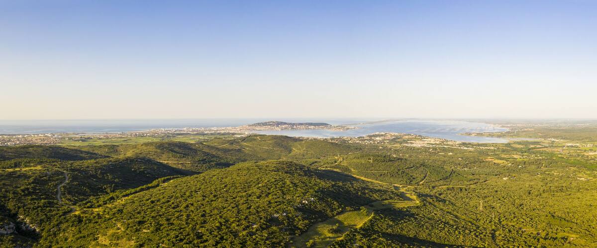 A mountainous landscape with a river and a distant city.