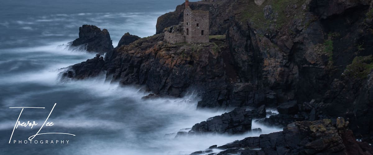 A coastal stone structure on a rocky cliff overlooking the sea.