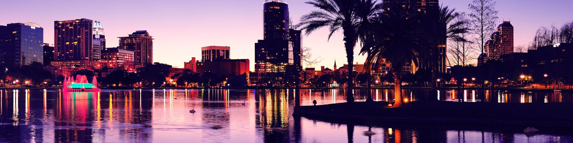 Orlando downtown skyline panorama silhouette over Lake Eola at dusk with urban skyscrapers