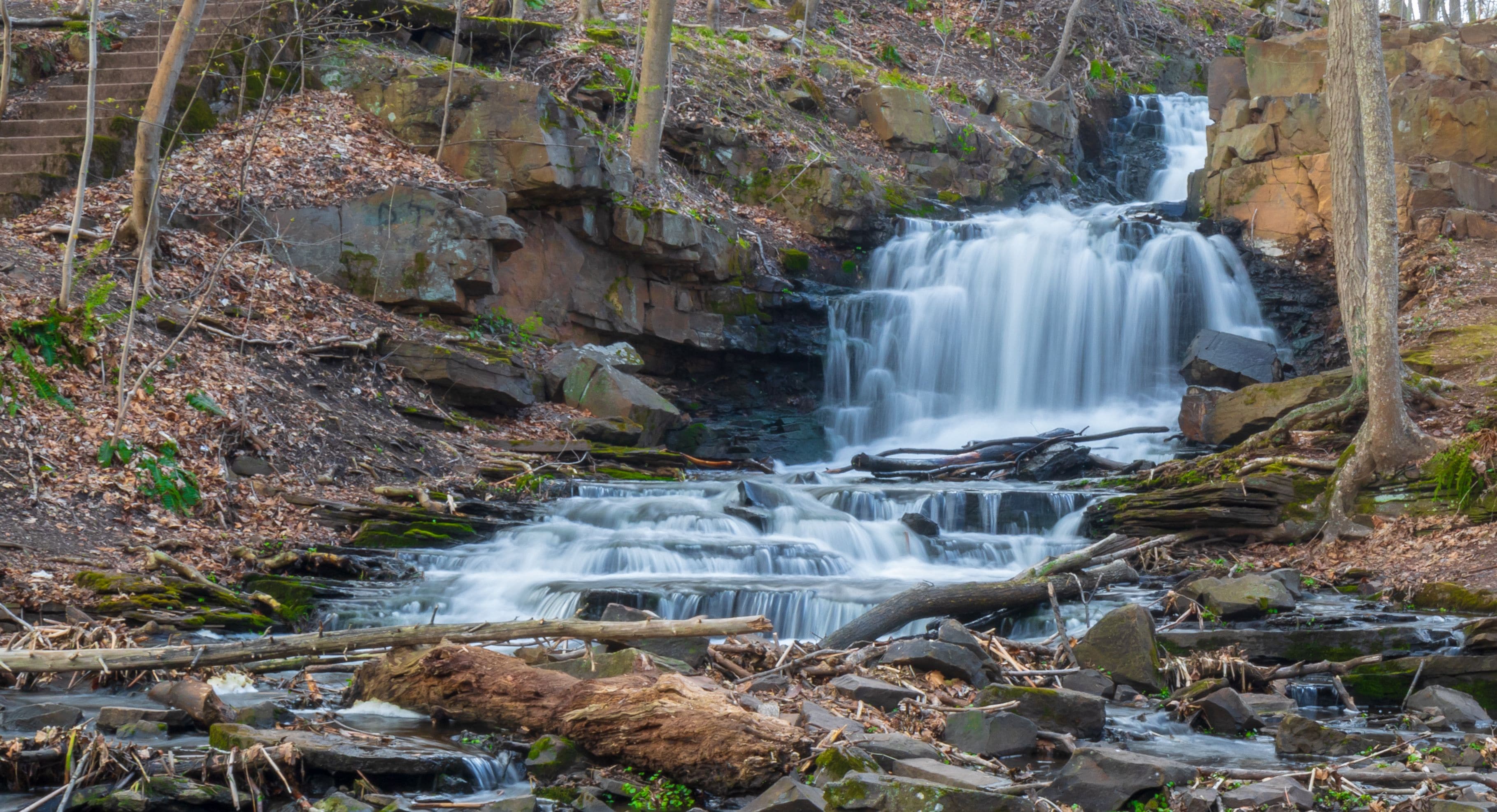 A waterfall cascading over rocks in a forested area.