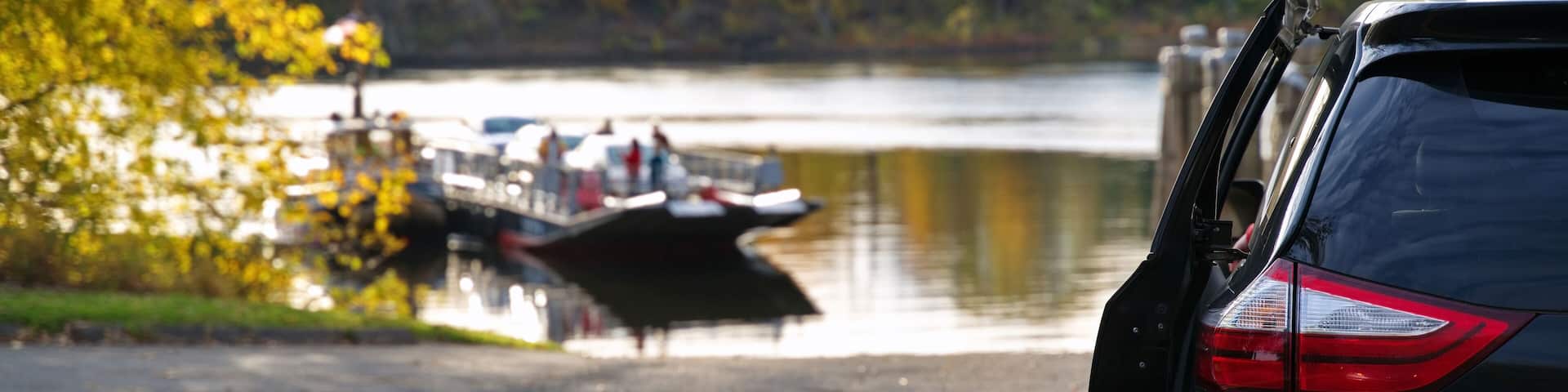 Family minivan waiting for New England traditional ferry to offload vehicles and people to cross the Connecticut River.