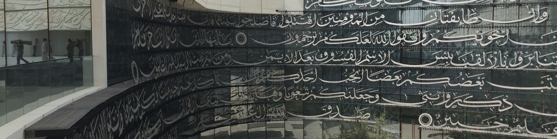 Un edificio moderno con caligrafía árabe en su fachada.