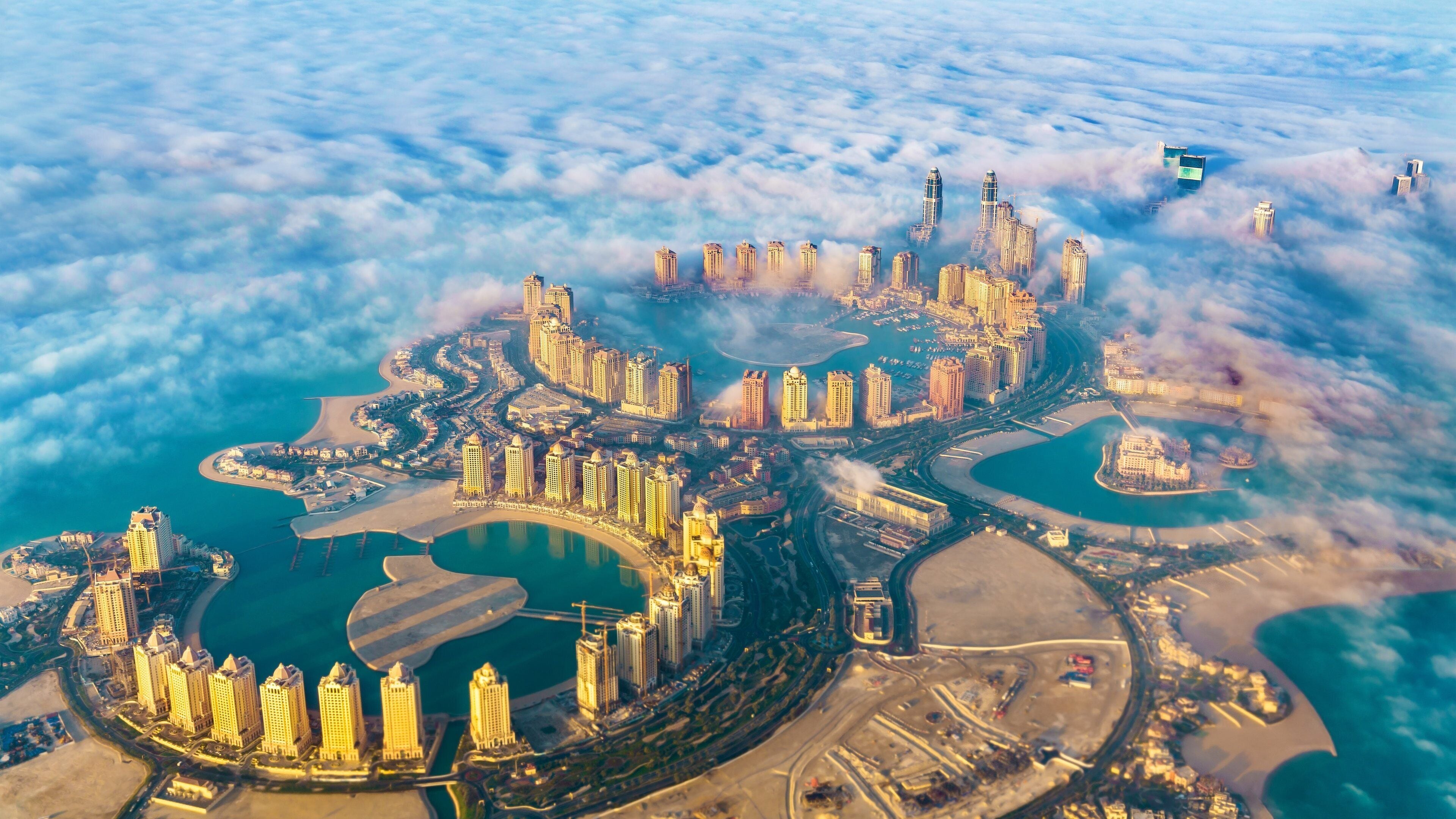 A coastal city with a marina, high-rise buildings, and a large body of water.
