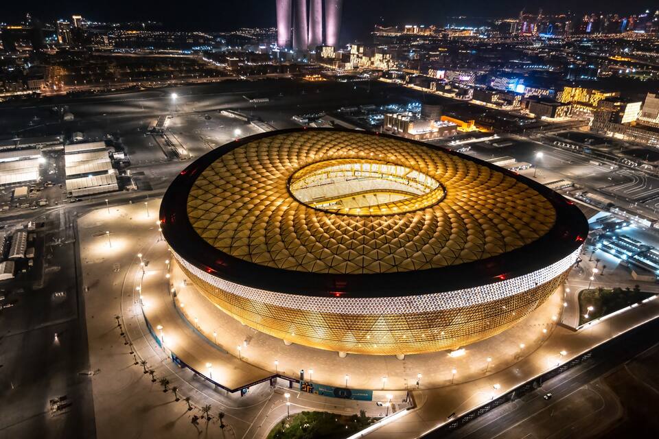 Un grand stade circulaire, surmonté d’un toit doré, entouré de routes et d’immeubles.