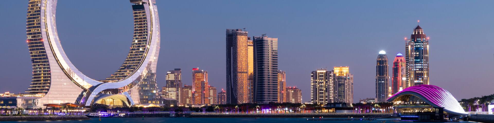 Crescent tower from Al Maha Island in Qatar, with a brightly blue sky before sunset . Lusail, Qatar