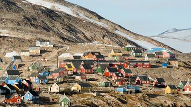A coastal village with colorful houses and a rocky landscape.