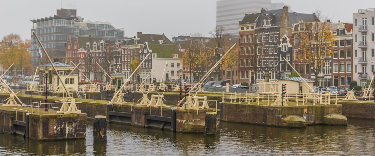 A canal with boats, a bridge, and historic buildings along the water.
