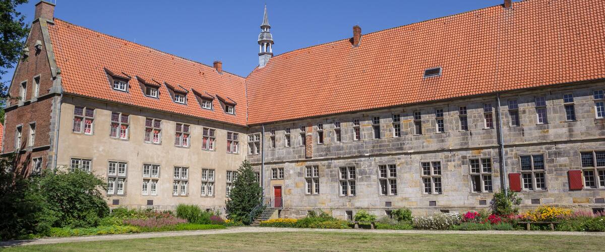 A historic building with a red-tiled roof and a prominent tower.