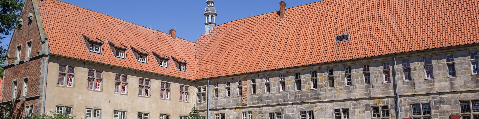 A historic building with a red-tiled roof and a prominent tower.