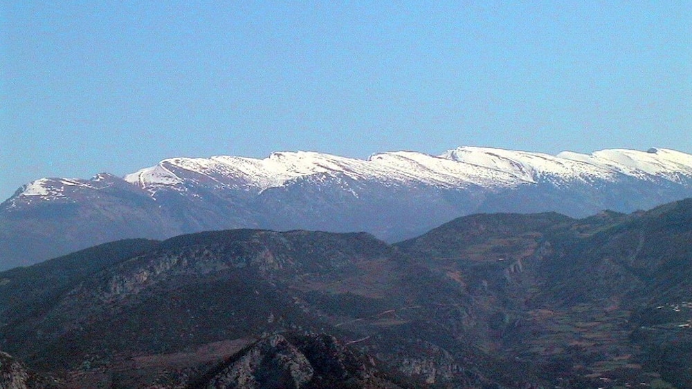 A snow-capped mountain range with rugged terrain and valleys.