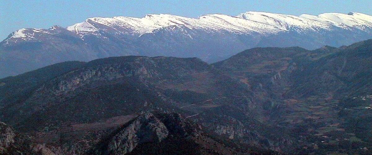 A snow-capped mountain range with rugged terrain and valleys.