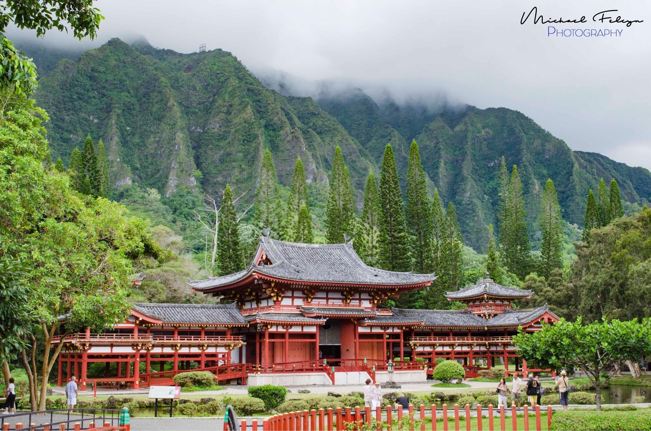 A traditional Japanese temple surrounded by lush greenery and mountains.