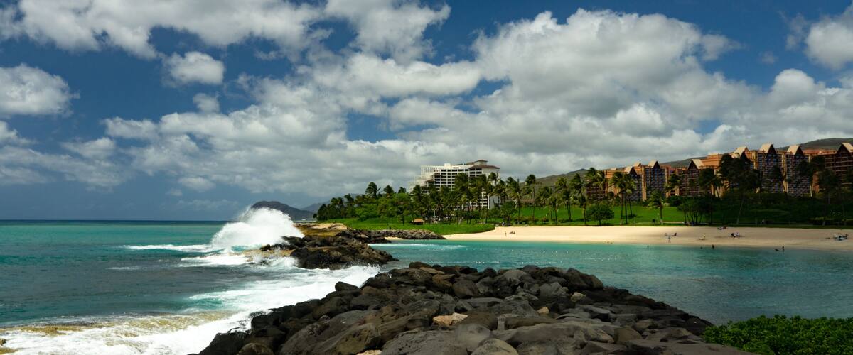 Rocky Shoreline of Ko Olina resort on the island of Oahu in Hawaii crashing waves palm trees a tropical paradise